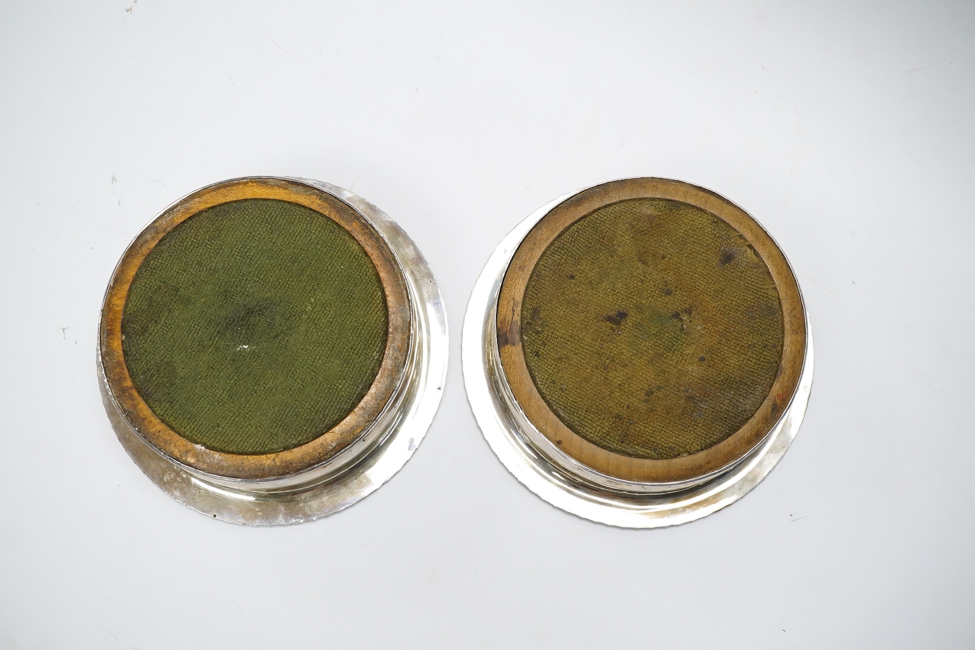 A pair of George III silver wine coasters, by Thomas & John Settle, with gadrooned borders and turned wooden bases, Sheffield, 1821, diameter 15.7cm. Condition - poor to fair